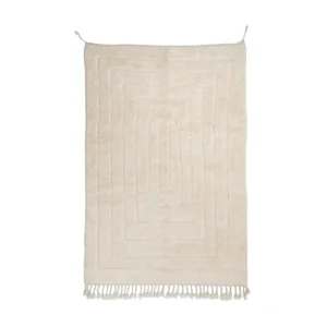 Rectangular beige bath mat with a geometric border pattern and short fringe tassels along the bottom edge, displayed against a white background.