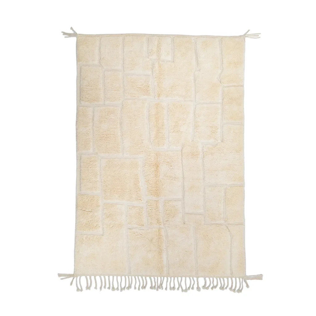 A rectangular cream-colored rug with a geometric pattern and fringe on the short sides.