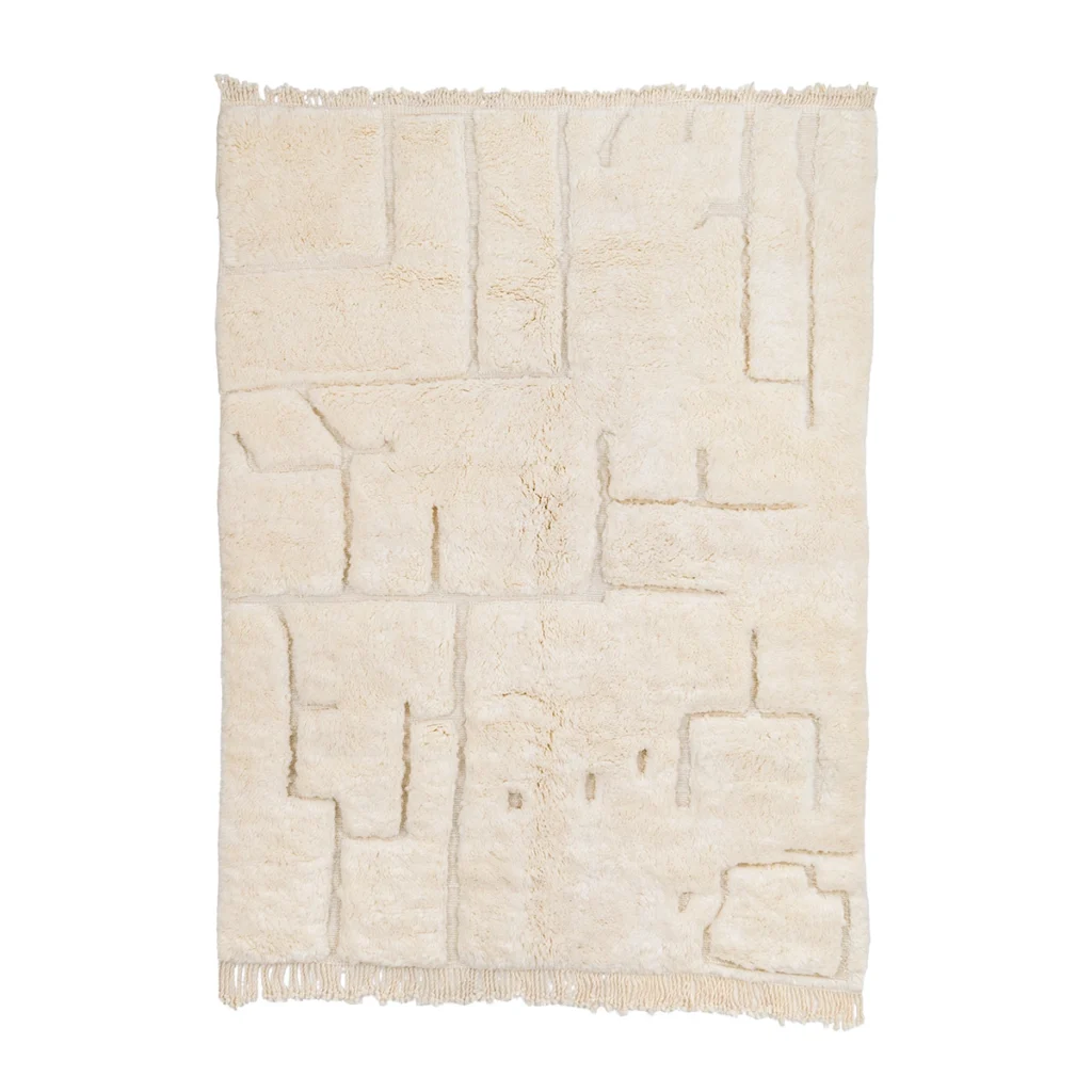 A rectangular off-white rug with a textured, geometric pattern and fringe on both shorter edges, photographed on a white background.