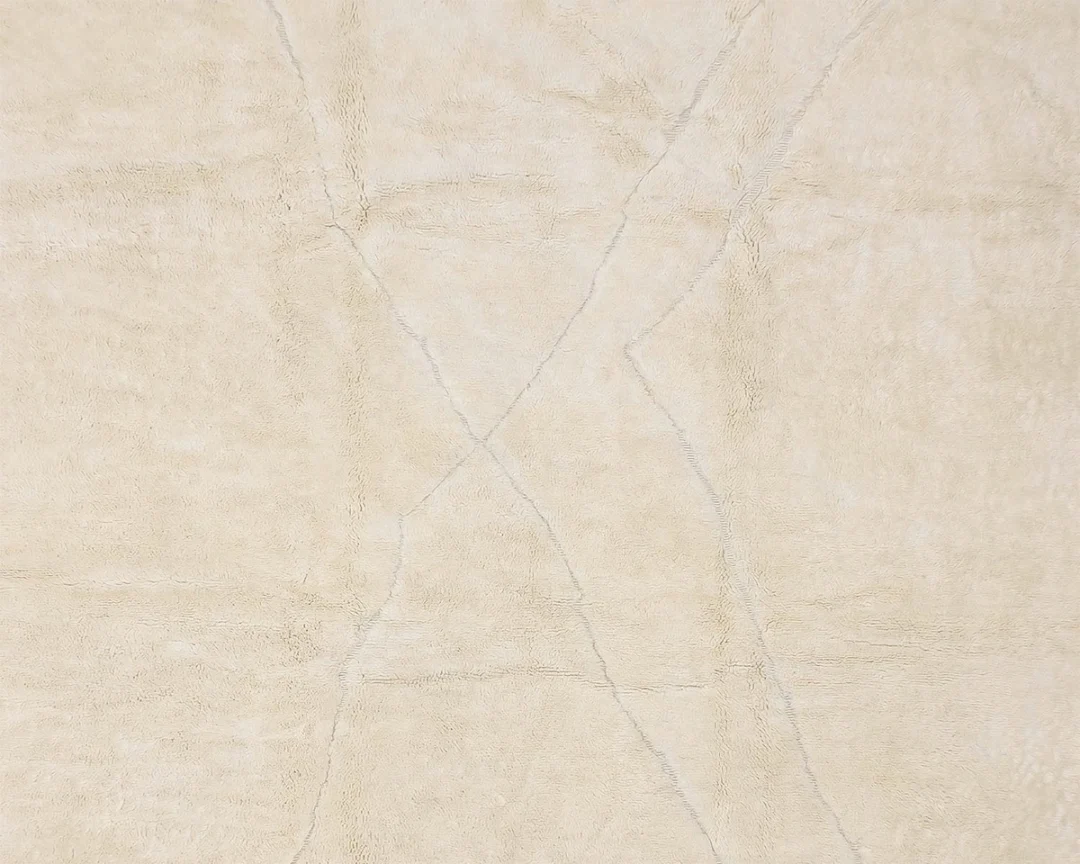 Beige textured surface with faint intersecting lines and subtle variations in shading.