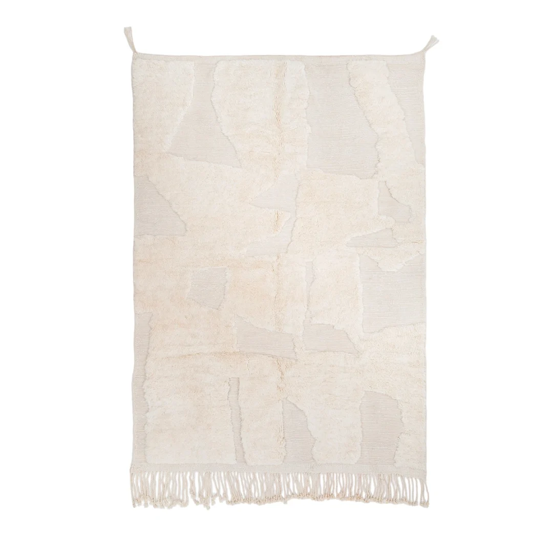 Rectangular cream-colored area rug with abstract textured patterns and tasseled fringe along the bottom edge, displayed on a white background.