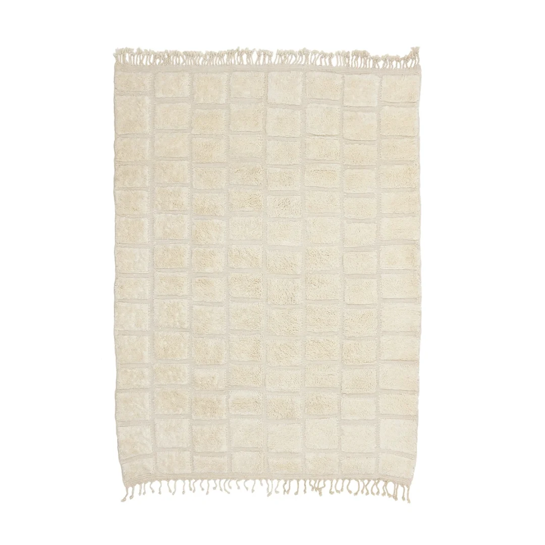 Rectangular cream-colored rug with a grid pattern and short fringes on both shorter edges, displayed on a white background.