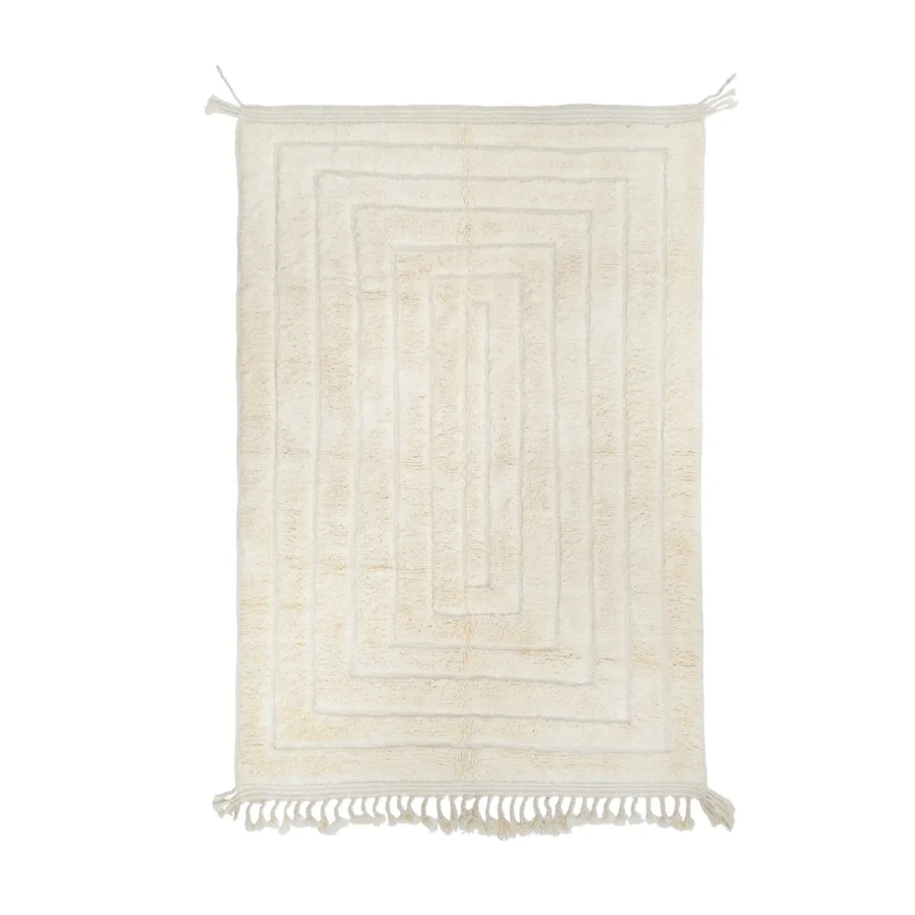 A rectangular cream-colored rug with a geometric pattern, fringe on both short ends, and a textured surface.
