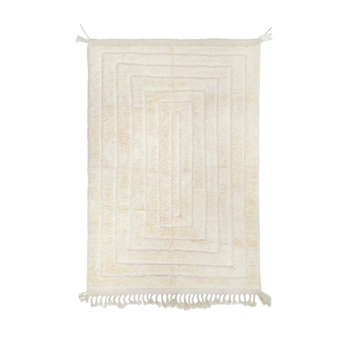 A rectangular cream-colored rug with a geometric pattern, fringe on both short ends, and a textured surface.