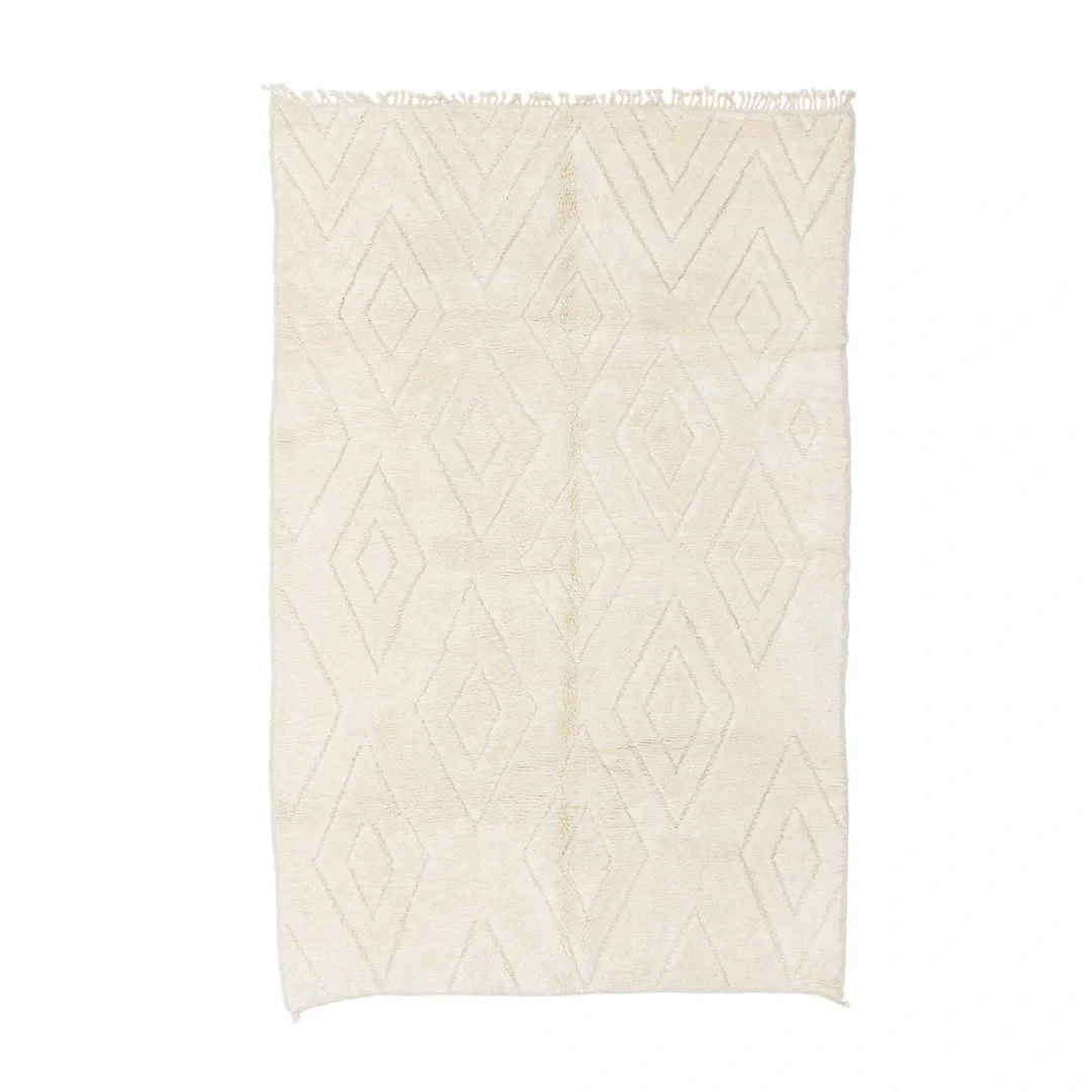 A rectangular cream-colored rug with a subtle diamond pattern and fringed edges at one end.