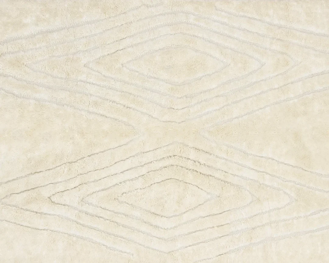 Beige textured rug with a geometric diamond pattern created by raised and recessed lines.