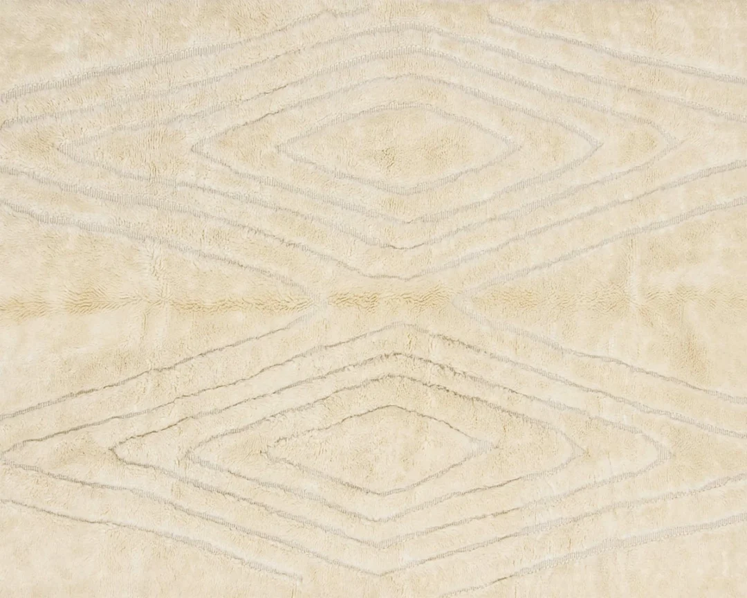 Close-up of a beige textured rug with a symmetrical diamond pattern formed by slightly raised lines.