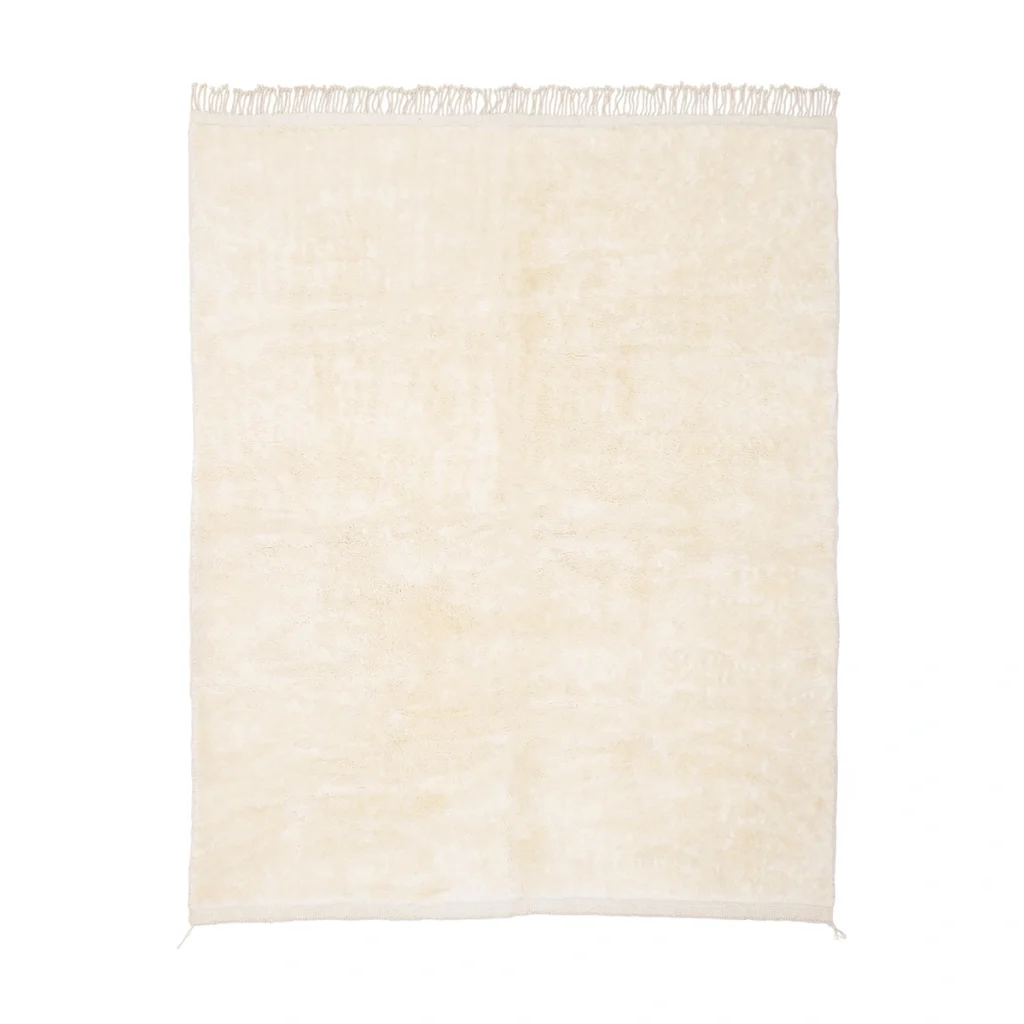 A rectangular, cream-colored rug with short fringe along the top edge, displayed on a white background.