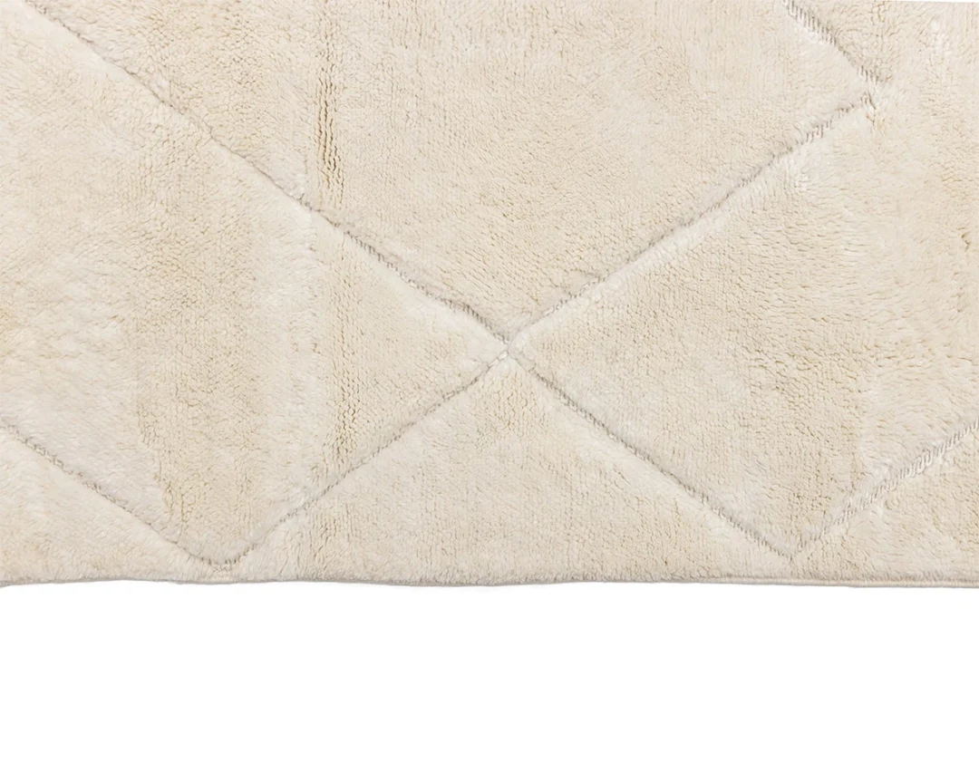 Close-up of a beige, plush rug with a subtle diamond pattern, shown from above.