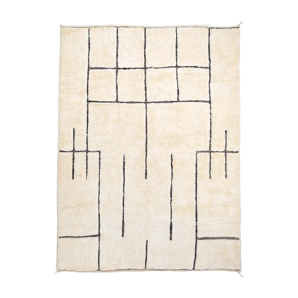 A cream-colored rectangular rug featuring a geometric pattern of irregular black lines forming rectangles and intersecting shapes.