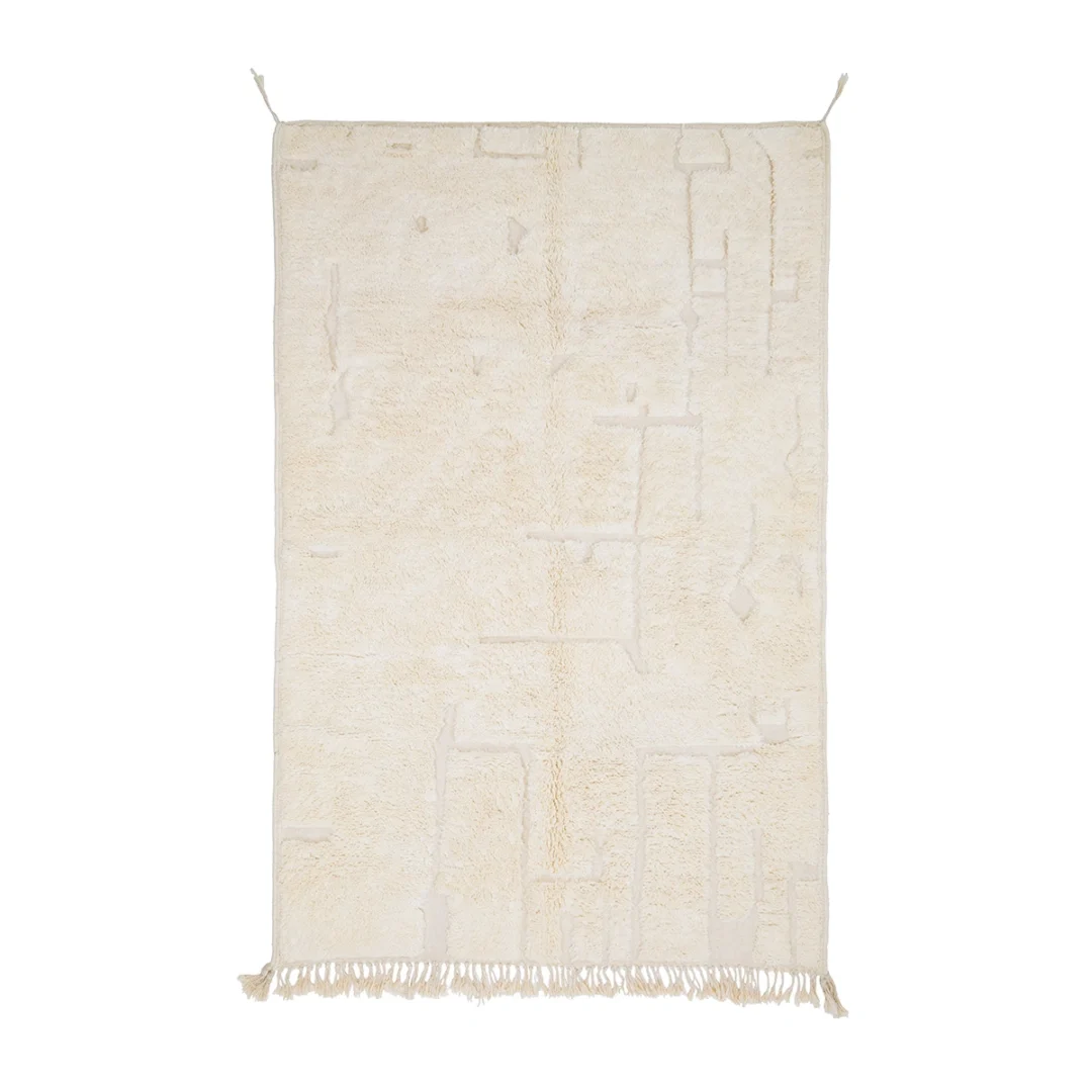 A rectangular cream-colored rug with subtle geometric patterns, fringe at the bottom, and two small loops at the top corners.