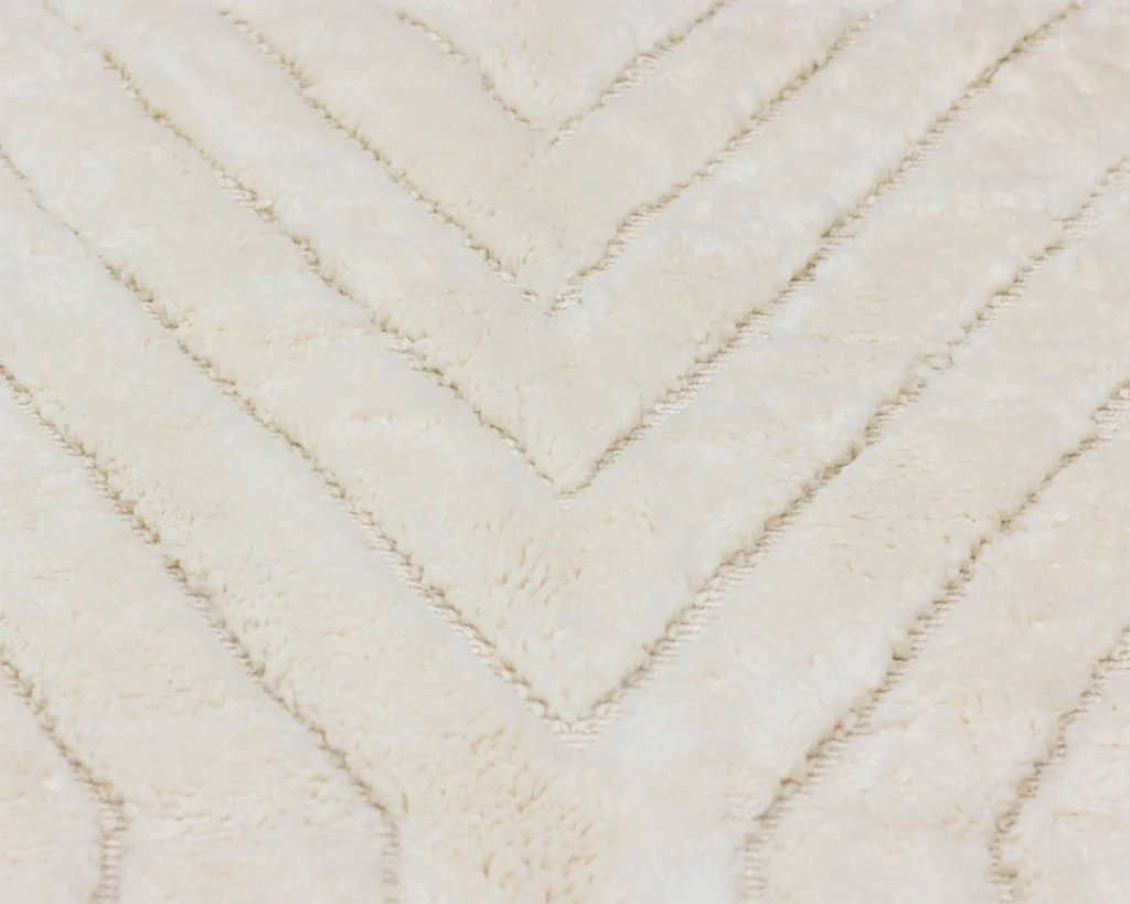 Close-up of a cream-colored, fuzzy fabric with a raised chevron pattern.