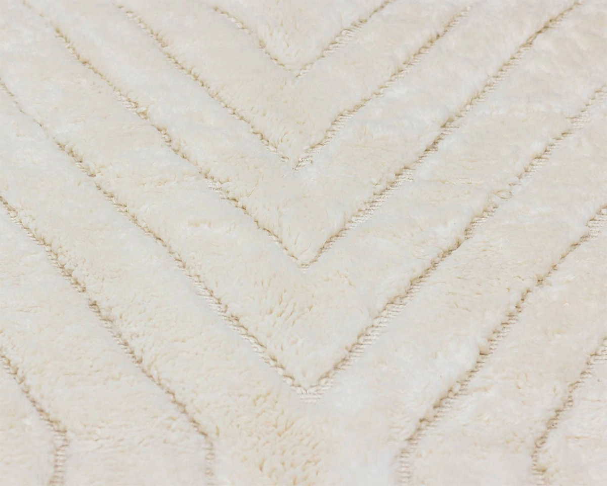 Close-up of a cream-colored, fuzzy fabric with a raised chevron pattern.