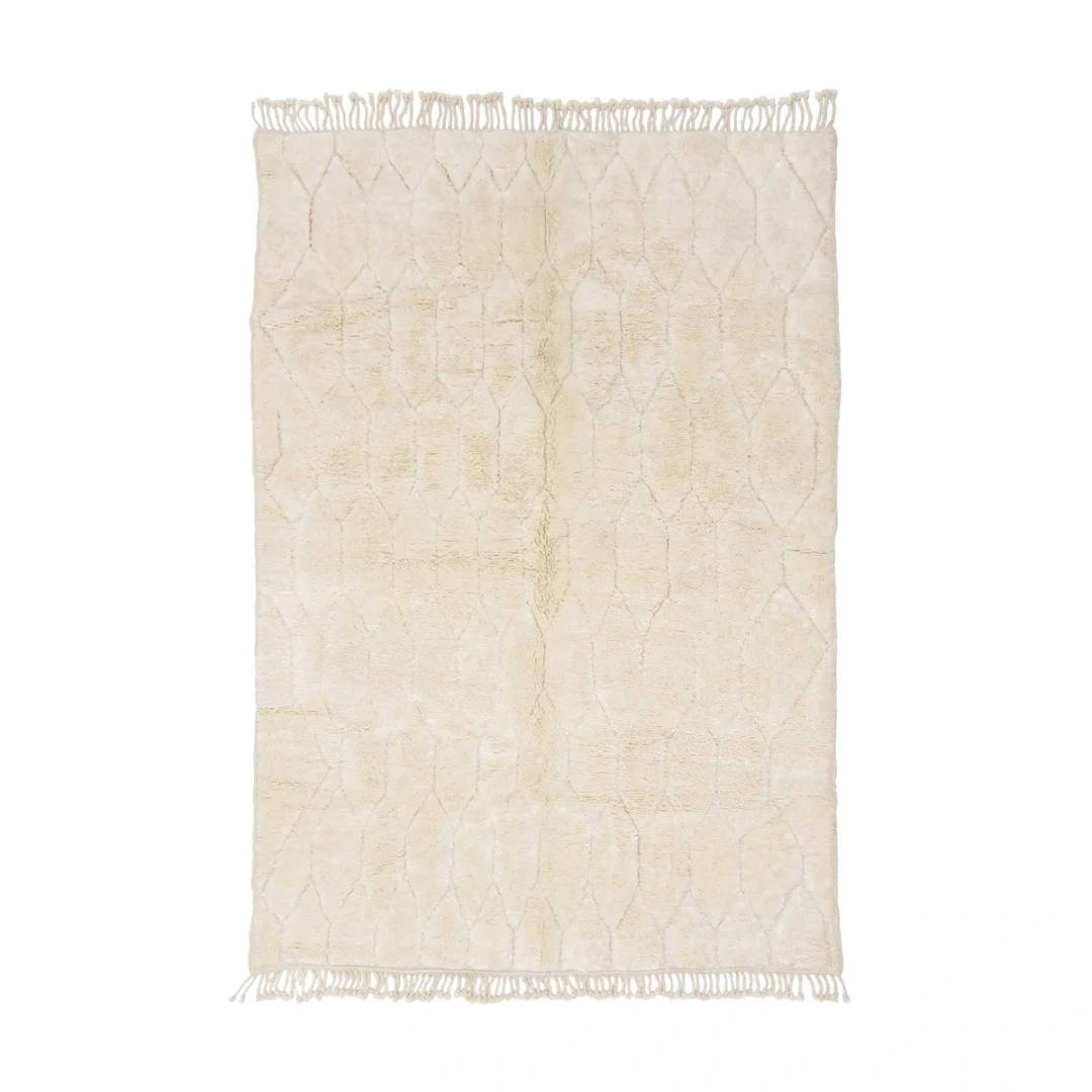 A rectangular beige rug with a subtle geometric pattern and fringed edges on the shorter sides.
