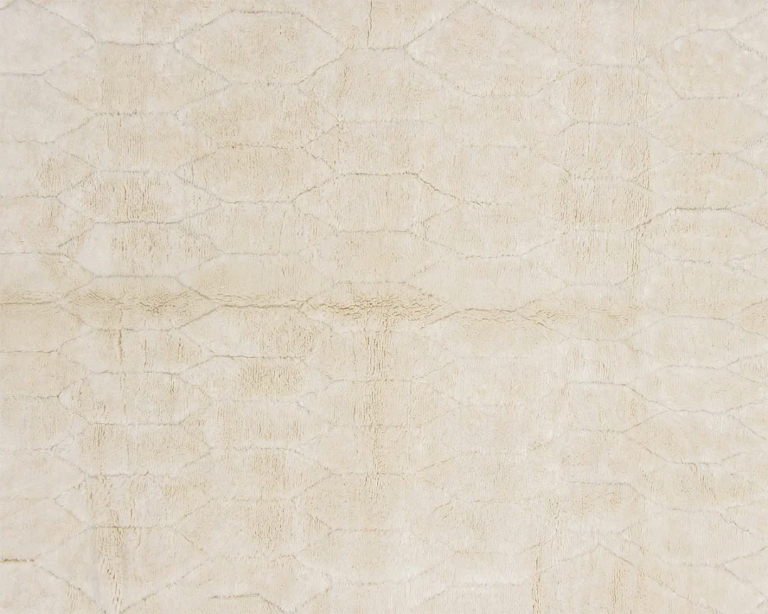 Close-up of a cream-colored textured rug with a subtle, irregular geometric pattern.