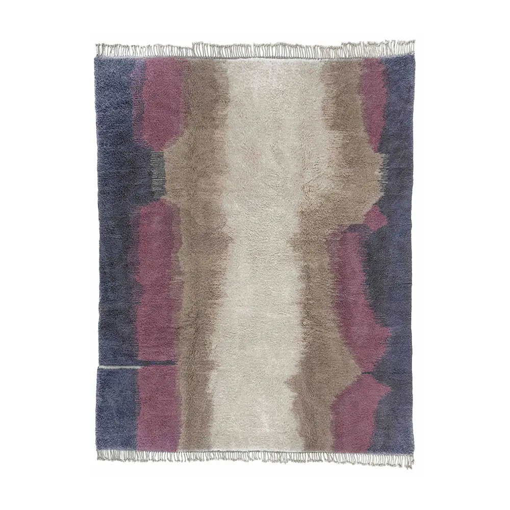 This luxury rug features a rectangular design with an abstract pattern in shades of purple, beige, and ivory. The fringed edges enhance its elegant appeal, adding a touch of sophistication to any room.