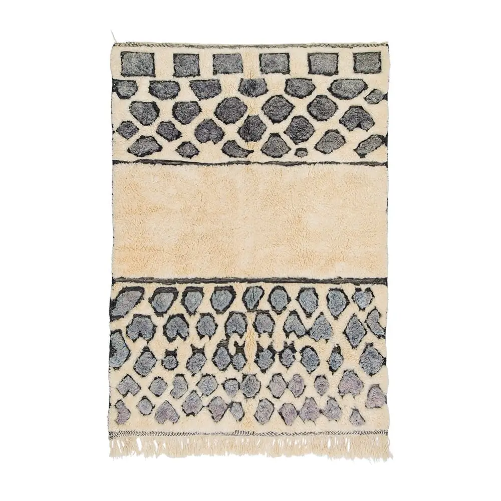Hand-knotted rectangular rug with a cream background, black abstract spotted patterns, a row of squares at the top, and fringe along the bottom edge—an authentic Moroccan rug with artisanal craftsmanship.