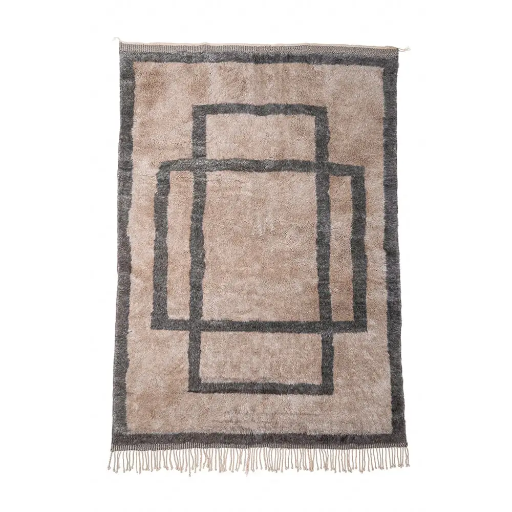 Rectangular beige rug with a dark border and three overlapping dark rectangles in the center; short fringe along the shorter edges.