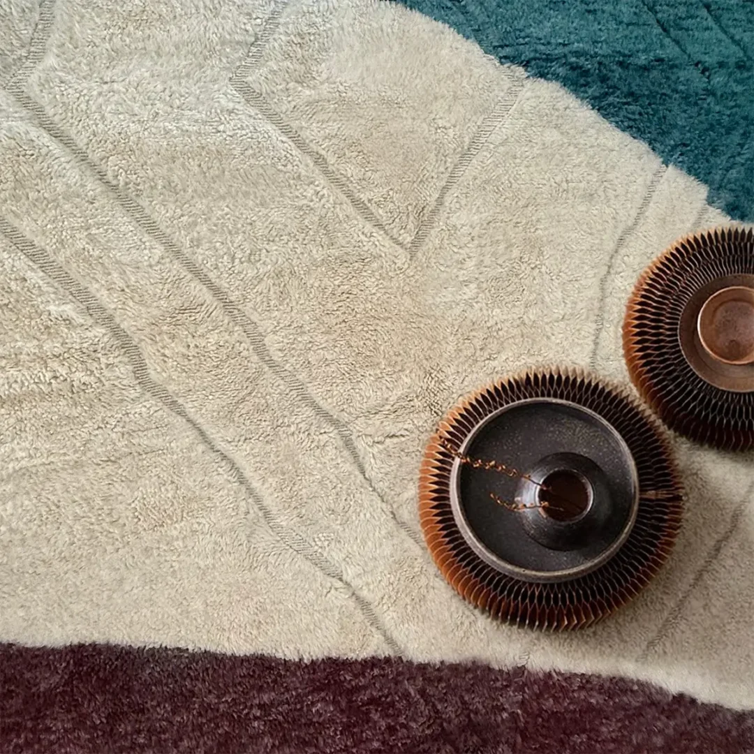 Azele Studio teal and ivory area rug corner detail showing deep red and teal abstract pattern